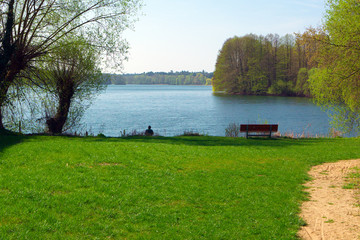Early spring - A man sitting and fishing at a beautiful lake