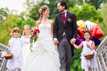 Hochzeit Braut und Bräutigam mit Blumenkinder im weißen Kleid