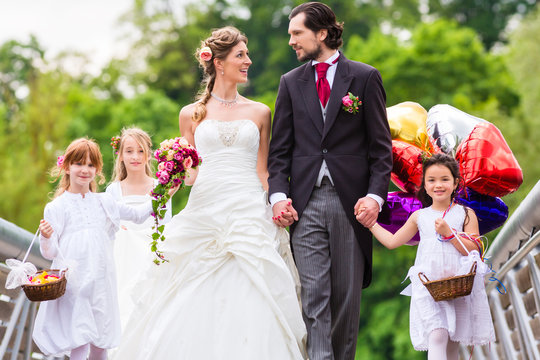 Hochzeit Braut und Br&auml;utigam mit Blumenkinder im wei&szlig;en Kleid