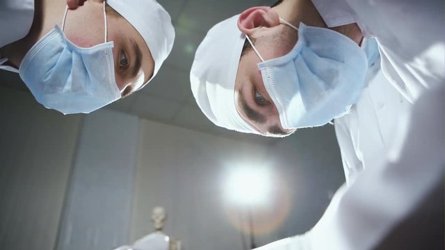 Faces of surgeons watching operation