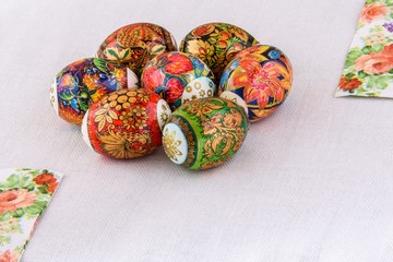  Easter eggs with bright lacquer paintings on a light background of natural linen tablecloths