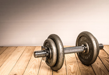 Dumbbells , weight plates on wooden background for bodybuilder. Concept for sport player or workout. gym of accessories for fitness