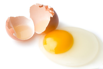 A broken chicken egg lies on a white background with a shell, yolk and spilled protein, isolated
