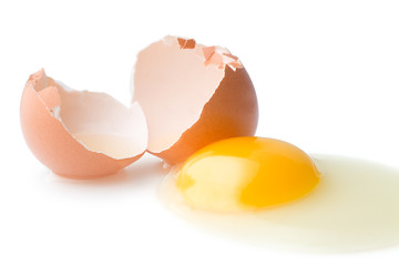 A broken chicken egg lies on a white background with a shell, yolk and spilled protein, isolated
