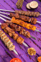 A shish kebab on skewers with fried vegetables and spices