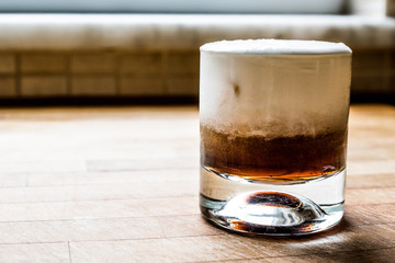 White Russian Cocktail on wooden surface.