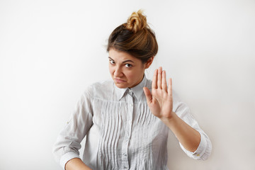 Portrait of young woman making stop gesture with her hand. Young woman with funny facial...
