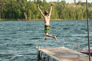Fototapeta na wymiar Boy jumping off dock