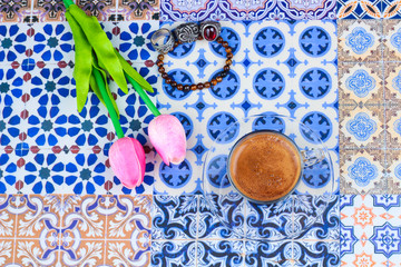 Cup of Arabian Coffee on an Oriental Colorful Background / Cup of Espresso on an Oriental Colorful Background with Flowers, Rings, and Tamr dates 
