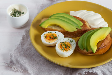 Open sandwiches with avocado, eggs and sauce