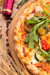 Pizza with olives, tomatoes and arugula, grated cheese and sauce
