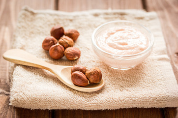 cosmetic for women with hazelnut scrub on desk background