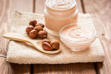 Obraz na płótnie Canvas spa concept with almond nuts and scrub on wooden background