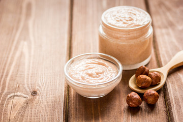 cosmetic for women with hazelnut scrub on desk background