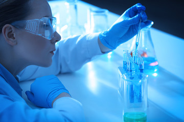 Scientist dropping a sample into test tube