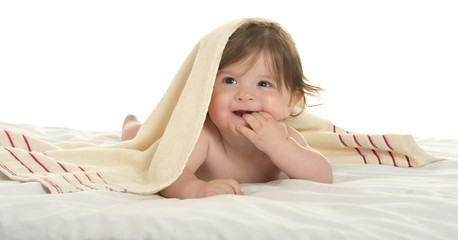 Baby girl lying under blanket