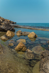 Fototapeta na wymiar Beautiful scenery on the shores of the Mediterranean Sea in North Cyprus. Rocky shore of the northern sea. Sunny day in Cyprus. Calm sea.