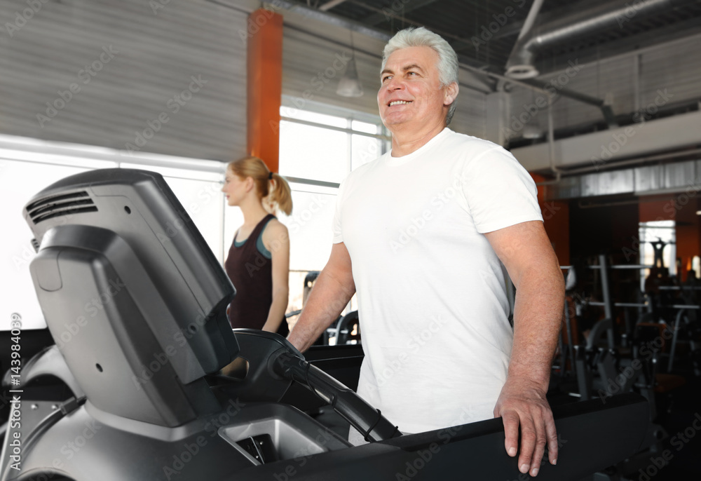 Sticker Senior man running on treadmill in gym