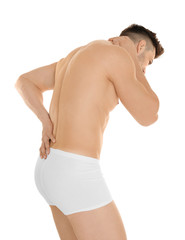 Young man suffering from back pain on white background