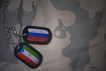 army blank, dog tag with flag of russia and equatorial guinea on the khaki texture background....