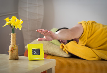 Sleeping man turns off the alarm clock in the morning, wake-up.