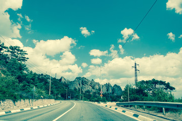Highway in mountains near sea Crimea in clear sun, cloudy day