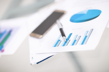Financial close-up background. Financial accounting graphs, pencil, phone.