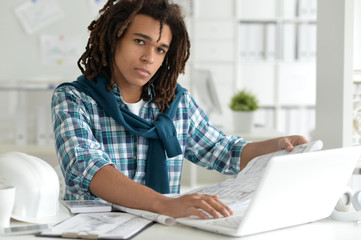 Portrait of a young business man with a laptop