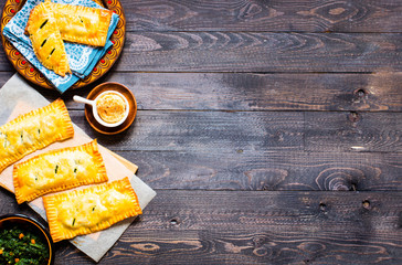 Delicious pie with spinach, made at home, on a wooden background,
