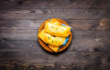 Delicious pie with spinach, made at home, on a wooden background,