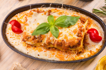 The lasagna, is served in sauce Bershamel, tomatoes and greens