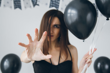 Fototapeta premium Girl in a black dress with black balloons