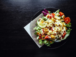 Caesar salad with prawns on the wooden table