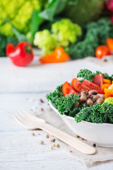 Healthy vegan buddha bowl with kale leaves and raw vegetables