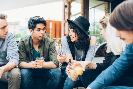 Group of friends multiethnic millennials  sitting drinking and chatting - socializing, interaction, friendship concept