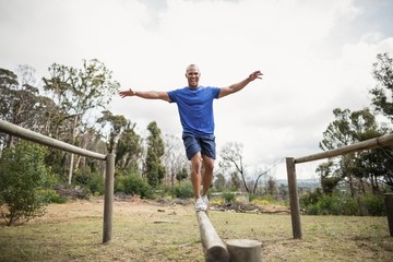Fit man balancing on hurdles during obstacle course training