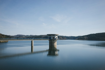Turm im Wasser am Staudamm eines Sees
