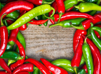 fresh red and green chili on old wood background. selective focus image, space for advertising text 