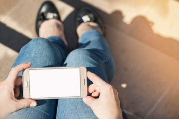 Woman sitting on the stairs, holding modern smartphone, image with sunlight  flash effect