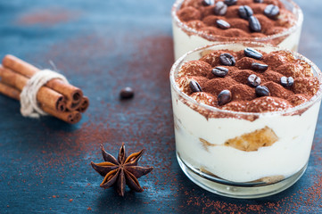 tiramisu in a glass decorated with coffee beans on a dark background