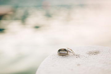 Obraz na płótnie Canvas Wedding rings on the rocks near the sea. Wedding jewelry.