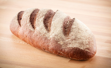 Loaf of bread on wooden background