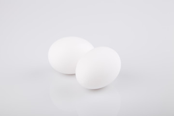 Two white eggs on a white surface. Isolated on white background.