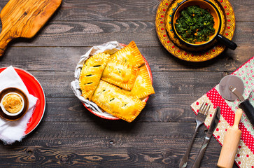 Delicious pie with spinach, made at home, on a wooden background,