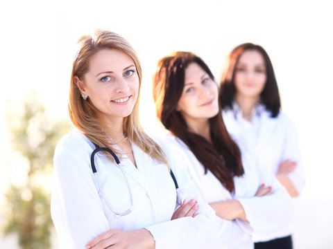 Portrait of three confident female doctors standing with arms crossed