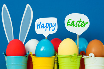 Bright  dyed eggs in colored buckets with speech bubbles. Happy Easter Card  