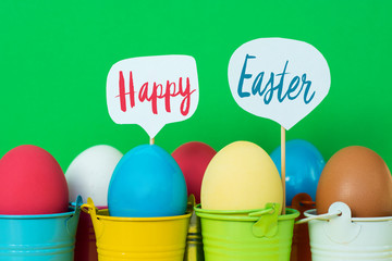 Bright  dyed eggs in colored buckets with speech bubbles. Happy Easter Card  