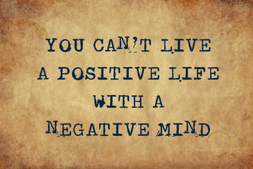 Inspiring motivation quote of you can't live a positive life with a negative mind with typewriter text. Distressed Old Paper with Typing image.
