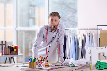 Young handsome fashion designer working at office