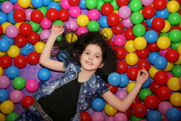 Fototapeta na wymiar Cute girl playing with plastic balls